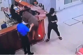 Hình ảnh người đàn ông chồm qua quầy làm thủ tục để hành hung nhân viên y tế. (Ảnh cắt từ clip)