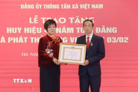 Bà Vũ Việt Trang, Ủy viên Ban Chấp hành Đảng bộ Khối các cơ quan Trung ương, Bí thư Đảng ủy, Tổng Giám đốc Thông tấn xã Việt Nam trao Huy hiệu 40 năm tuổi Đảng cho ông Thân Văn Hạnh. (Ảnh: Phương Hoa/TTXVN)