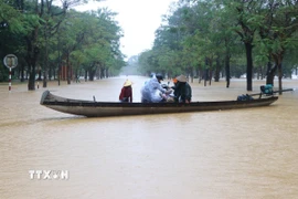 Nước ngập sâu, người dân Huế phải di chuyển bằng thuyền. (Ảnh: Nguyên Lý/TTXVN)