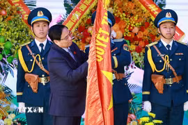Thủ tướng Phạm Minh Chính gắn Danh hiệu Anh hùng Lực lượng Vũ trang Nhân dân lên Quân kỳ Quyết thắng của Quân chủng Phòng không-Không quân. (Ảnh: Dương Giang/TTXVN)