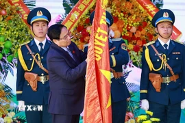 Thủ tướng Phạm Minh Chính gắn Danh hiệu Anh hùng Lực lượng Vũ trang Nhân dân lên Quân kỳ Quyết thắng của Quân chủng Phòng không-Không quân. (Ảnh: Dương Giang/TTXVN)