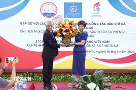 Đại diện Hãng Thông tấn Prensa Latina tại Việt Nam tặng hoa chúc mừng Thông tấn xã Việt Nam nhân Ngày Báo chí cách mạng Việt Nam. (Ảnh: Văn Điệp/TTXVN)