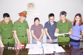 Các bị can Nguyễn Tư Duy, Lê Thị Lan Anh và tang vật vụ án. (Ảnh: Thanh Tuấn/TTXVN)