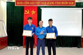 Thừa ủy quyền của Ban Bí thư Trung ương Đoàn, Phó Bí thư Tỉnh đoàn Quảng Trị Nguyễn Quốc Toản trao tặng Huy hiệu “Tuổi trẻ dũng cảm” cho đoàn viên Võ Hoàng Vũ và Nguyễn Võ Huy Công. (Ảnh: TTXVN phát)