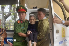 Lực lượng công an xã Đan Hải hỗ trợ đưa người dân đến nơi sơ tán. (Ảnh: Hữu Quyết/TTXVN)