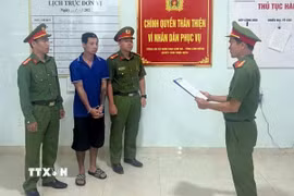 Đối tượng Nguyễn Xuân Bình nghe đọc lệnh khởi tố tại cơ quan điều tra. (Ảnh TTXVN phát)