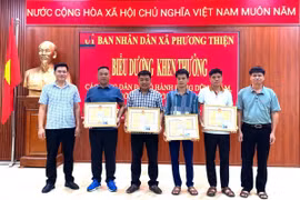 Lãnh đạo Ủy ban Nhân dân xã Phương Thiện trao giấy khen cho 5 công dân. (Ảnh: TTXVN phát)