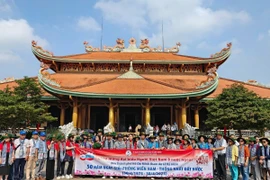 Chủ nhiệm Ủy ban Nhà nước về người Việt Nam ở nước ngoài Nguyễn Trung Kiên cùng các kiều bào dâng hương tưởng niệm các anh hùng liệt sỹ tại Đền Bến Dược. (Ảnh: TTXVN phát)