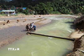 Trước đây lòng suối Nậm Ngân đoạn chảy giữa bản chỉ rộng khoảng hơn 10m, sau khi lũ ống, lũ quét xảy ra, lòng suối đã mở rộng lên gấp 5 lần và thay đổi dòng chảy. (Ảnh: Xuân Tiến/TTXVN)