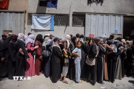 Người dân Palestine tập trung tại một điểm phân phát hàng cứu trợ ở Gaza. (Ảnh: THX/TTXVN)