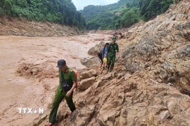Tổ công tác vất vả di chuyển theo vách đá ngược thượng nguồn sông Nậm Mộ trên hành trình tiếp cận bản Cha Nga (xã Mỹ Lý, tỉnh Nghệ An). (Ảnh: TTXVN phát)
