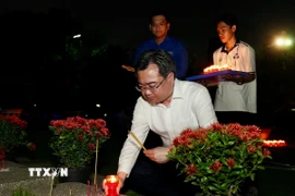 Ông Nguyễn Thanh Nghị, Phó Bí thư Thường trực Thành ủy Thành phố Hồ Chí Minh thắp nến tưởng niệm các anh hùng, liệt sỹ. (Ảnh: Thu Hương/TTXVN)
