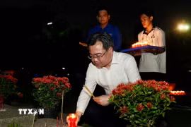 Ông Nguyễn Thanh Nghị, Phó Bí thư Thường trực Thành ủy Thành phố Hồ Chí Minh thắp nến tưởng niệm các anh hùng, liệt sỹ. (Ảnh: Thu Hương/TTXVN)