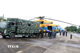 Lực lượng cứu trợ vận chuyển mỳ tôm, lương khô, nước... lên trực thăng để chuyển đến các xã phía Tây Nghệ An đang bị cô lập. (Ảnh: Văn Tý/TTXVN)
