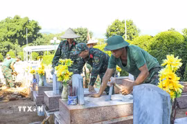 Chiến sỹ Bộ Chỉ huy Quân sự tỉnh Điện Biên tỉ mỉ hoàn thiện công đoạn trát vữa, cố định các hạng mục phần mộ sau khi lấy mẫu sinh phẩm xác định danh tính hài cốt liệt sỹ. (Ảnh: Xuân Tư/TTXVN)