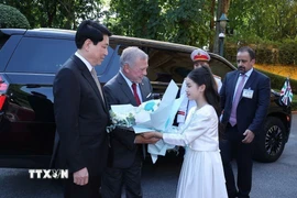 Thiếu nhi Thủ đô Hà Nội tặng hoa Quốc vương Jordan Abdullah II Ibn Al Hussein tại lễ đón. (Ảnh: Lâm Khánh/TTXVN)