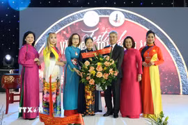 Đại sứ Nguyễn Đắc Thành và Phu nhân tặng hoa cho bà Trịnh Thị Mùi, Chủ tịch Hội Nữ Doanh nhân Việt Nam tại châu Âu. (Ảnh: Thu Hằng/TTXVN)