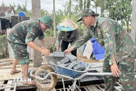 Chiến sỹ Đoàn Kinh tế-Quốc phòng 207/Quân khu 5 hỗ trợ xây sửa nhà cho người dân. (Ảnh: Tường Quân/TTXVN)