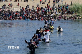 Người di cư vượt sông Rio Bravo ở biên giới Mỹ-Mexico. (Ảnh: THX/TTXVN)