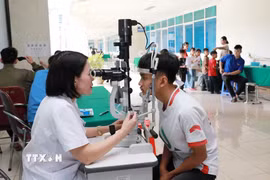 Bác sỹ khám mắt miễn phí cho học sinh có hoàn cảnh khó khăn trên địa bàn tỉnh. (Ảnh: Quý Trung/TTXVN)