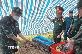 Cất bốc hài cốt liệt sỹ tại khu vực ấp Phú Bình, xã Thanh An. (Ảnh: TTXVN phát)