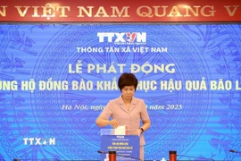 Tổng Giám đốc TTXVN Vũ Việt Trang ủng hộ đồng bào khắc phục hậu quả bão lũ. (Ảnh: Tuấn Anh/TTXVN)