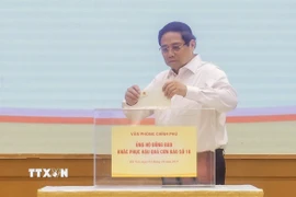 Thủ tướng Phạm Minh Chính quyên góp, ủng hộ đồng bào khắc phục hậu quả bão số 10. (Ảnh: Dương Giang/TTXVN)