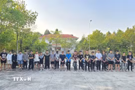 Các đối tượng cùng phương tiện bị bắt giữ tại cơ quan công an. (Ảnh: TTXVN phát)