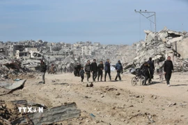 Người dân trở về nhà ở phía bắc Dải Gaza, sau khi lệnh ngừng bắn giữa Israel và Phong trào Hồi giáo Hamas có hiệu lực. (Ảnh: THX/TTXVN)