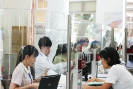 Cán bộ, công chức tại Trung tâm Hành chính công Quận 1 (phường Sài Gòn mới) khẩn trương xử lý hồ sơ. (Ảnh: Hữu Duyên/TTXVN)