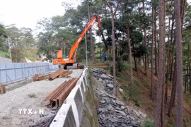 Đơn vị thi công đóng cọc ván thép để gia cố tạm thời mặt đường chống sạt lở trên đèo Prenn. (Ảnh: Chu Quốc Hùng/TTXVN)