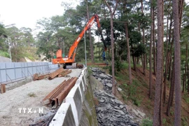 Đơn vị thi công đóng cọc ván thép để gia cố tạm thời mặt đường chống sạt lở trên đèo Prenn. (Ảnh: Chu Quốc Hùng/TTXVN)