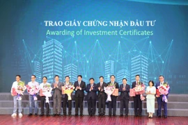 Phó Thủ tướng Nguyễn Chí Dũng cùng các lãnh đạo tỉnh Bắc Ninh chụp ảnh với đại diện các doanh nghiệp được trao chứng nhận, điều chỉnh đầu tư. (Ảnh: Thanh Thương/TTXVN)