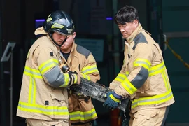 Lính cứu hỏa di chuyển một cục pin lithium-ion bị cháy trong vụ hỏa hoạn. (Nguồn: Yonhap)