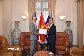 Đại sứ đặc mệnh toàn quyền Việt Nam tại Pháp Trịnh Đức Hải trao bản sao Quốc thư của Chủ tịch nước Lương Cường cho ông Mathieu Carmona, Phó Cục trưởng Cục Lễ tân, Bộ châu Âu và Ngoại giao Pháp. (Ảnh: TTXVN phát)