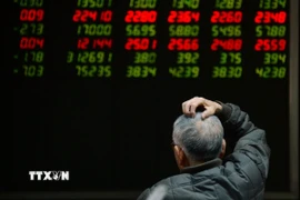 Nhà đầu tư theo dõi bảng chỉ số chứng khoán tại Bắc Kinh, Trung Quốc. (Ảnh minh họa. AFP/TTXVN)