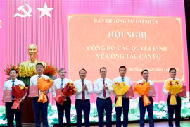 Phó Bí thư Thường trực Thành ủy Nguyễn Đình Vĩnh (thứ tư, từ trái sang) và Chủ tịch UBND thành phố Nguyễn Mạnh Hùng (thứ năm, từ trái sang) tặng hoa chúc mừng các đồng chí được điều động, bổ nhiệm và giao quyền.
