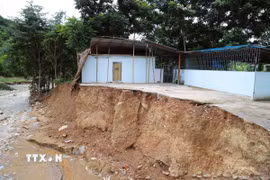 Tháng 7/2025, lũ ống, lũ quét gây sạt lở nghiêm trọng, làm biến dạng bờ suối và cuốn trôi hoàn toàn một ngôi nhà tại bản Huổi Xá (xã Nhôn Mai, tỉnh Nghệ An); phần còn lại của ngôi nhà “treo” bên vách sạt lở. (Ảnh: Xuân Tiến/TTXVN)