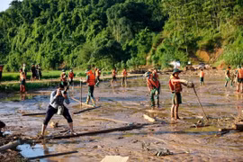 Phóng viên Dương Giang (Ban Biên tập Ảnh) tác nghiệp tại khu vực sạt lở đất ở làng Nủ, xã Phúc Khánh, huyện Bảo Yên, tỉnh Lào Cai (12/9/2024). (Ảnh: TTXVN)