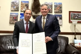 Thượng nghị sỹ Mỹ Steve Daines trao Nghị quyết của Thượng viện Mỹ kỷ niệm 30 năm bình thường hóa quan hệ ngoại giao Việt Nam-Mỹ cho Đại sứ Việt Nam tại Mỹ Nguyễn Quốc Dũng. (Ảnh: TTXVN phát)