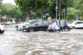 Các phương tiện di chuyển khó khăn trên đường Xuân Tảo. (Ảnh: Vietnam+)