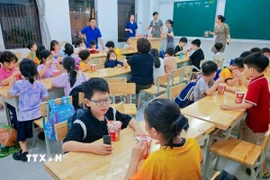 Trường Tiểu học Nguyễn Viết Xuân bố trí bữa ăn cho học sinh khi chưa có bố mẹ đón về. (Ảnh: TTXVN phát)