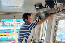 Ngư dân xã Long Hải, Thành phố Hồ Chí Minh, kiểm tra thiết bị giám sát hành trình trước khi ra khơi xuất bến. (Ảnh: Hoàng Nhị/TTXVN)