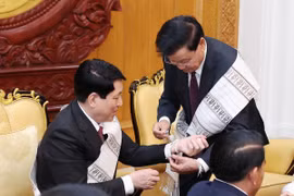 Tổng Bí thư, Chủ tịch nước Lào Thongloun Sisoulith buộc chỉ cho Chủ tịch nước Lương Cường. (Ảnh: Lâm Khánh/TTXVN)
