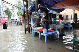 Người dân phố Triều Khúc kê cao bếp và các vật dụng để tiếp tục buôn bán trong cảnh ngập. (Ảnh: Vũ Quang/TTXVN)