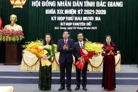 Bí thư Tỉnh ủy Bắc Giang Nguyễn Văn Gấu tặng hoa chức mừng tân Chủ tịch Hội đồng Nhân dân và Ủy ban Nhân dân tỉnh Bắc Giang. (Ảnh: Đồng Thúy/TTXVN)