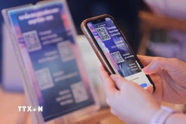 Du khách sử dụng điện thoại thông minh quét mã QR Code tìm kiếm thông tin về các điểm du lịch, điểm tham quan, ẩm thực… (Ảnh: Minh Quyết/TTXVN)
