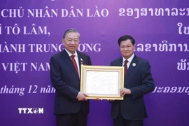 Tổng Bí thư, Chủ tịch nước Lào Thongloun Sisoulith trao tặng Huân chương Vàng Quốc gia của Nhà nước Lào cho Tổng Bí thư Tô Lâm. (Ảnh: Thống Nhất/TTXVN)