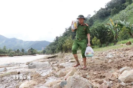 Lực lượng công an tiếp tế nhu yếu phẩm cứu trợ người dân vùng lũ xã Bác Ái Tây (Khánh Hòa). (Ảnh: Nguyễn Thành/TTXVN)