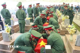 An táng các hài cốt liệt sỹ quân tình nguyện Việt Nam tại Nghĩa trang liệt sỹ Tông Khao. (Ảnh: Xuân Tư/TTXVN)
